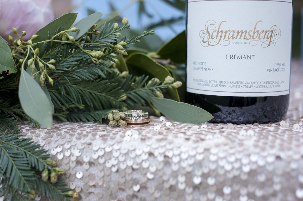 Wedding ring close up with wine and greenery by Jen Vazquez Photography gilroy wedding redwood retreat